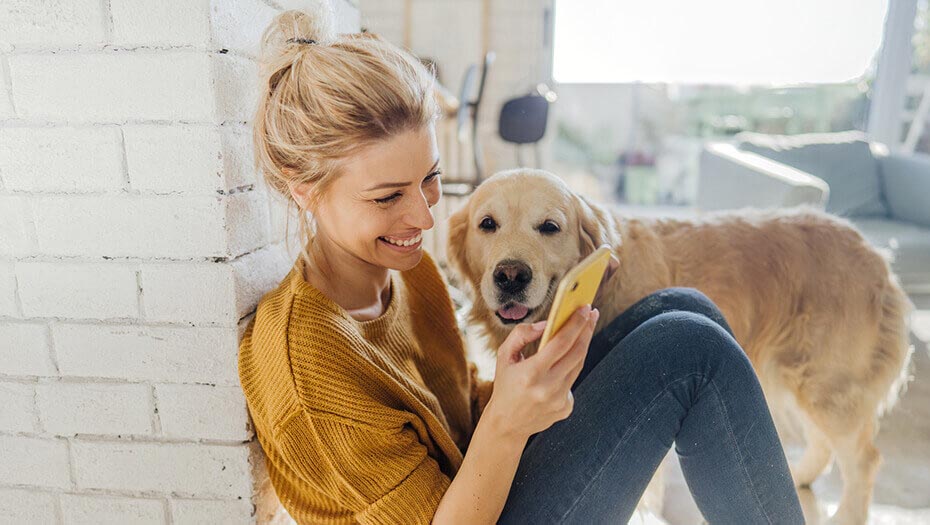 Woman sitting on floor looking at phone.